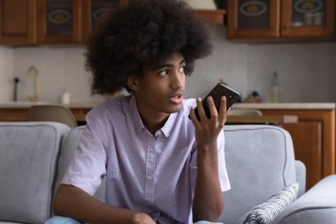 Ciddi Afrikalı hippi çocuk sesli mesaj kaydediyor.