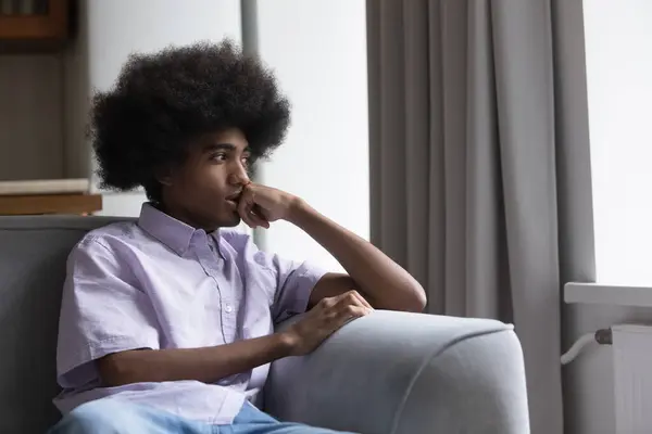 Thoughtful sad teen Black guy sitting on sofa — Stock Photo, Image