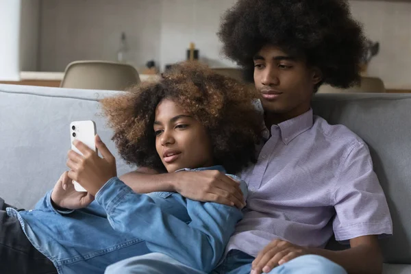 Afrikanisches verliebtes Teenie-Paar ruht sich auf der heimischen Couch aus — Stockfoto