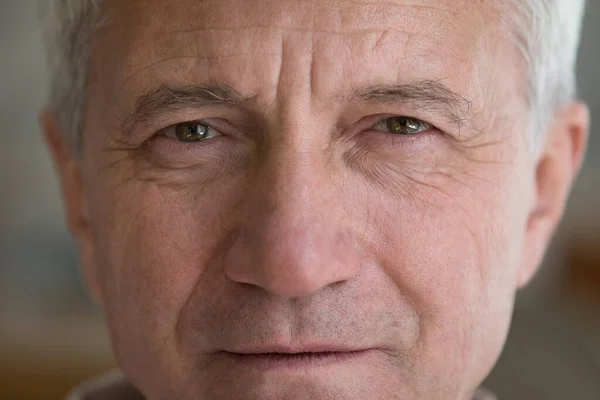 Gesicht eines ernstzunehmenden älteren Mannes mit braunen Augen, Falten — Stockfoto