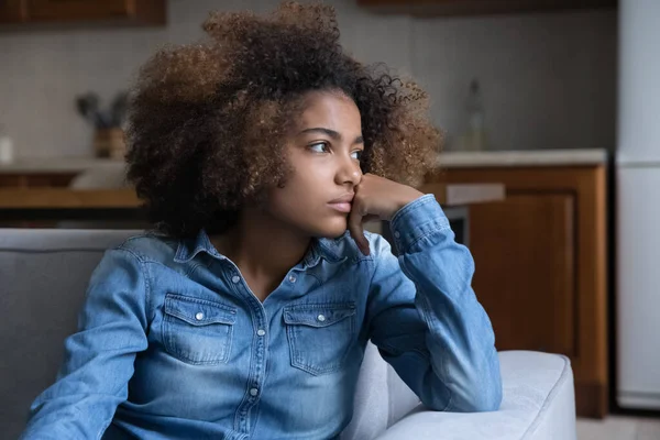 Frustrado pensivo adolescente Africano menina sentada no sofá em casa — Fotografia de Stock