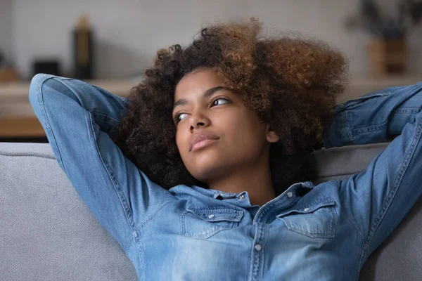 Thoughtful teen Black girl with Afro hairdo resting on sofa — Stock Photo, Image