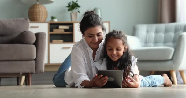 Anne ve kızı yerde yatarken tablet kullanarak iyi eğlenceler. — Stok video