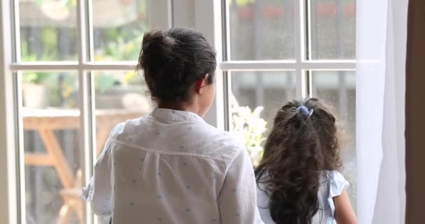 Mujer abrazo hija, mirando juntos por la ventana saludo amigo — Vídeo de stock