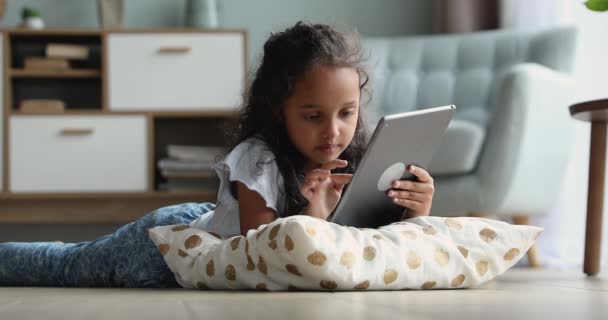 Menina indiana deitada no chão quente usando tablet digital — Vídeo de Stock