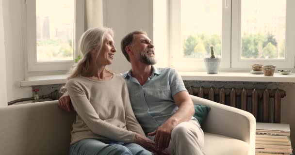 Despreocupada pareja sentarse en el sofá disfrutar de la conversación mirando a la distancia — Vídeos de Stock