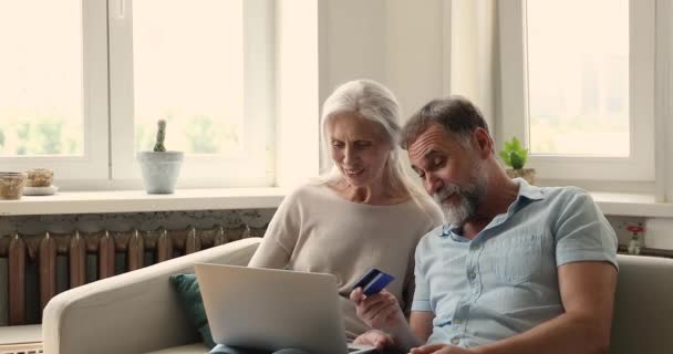 Casal mais velho usando laptop e cartão de crédito comprar serviços online — Vídeo de Stock