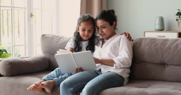 Cheerful Indian mother read fairytale book to her little daughter — Stock Video