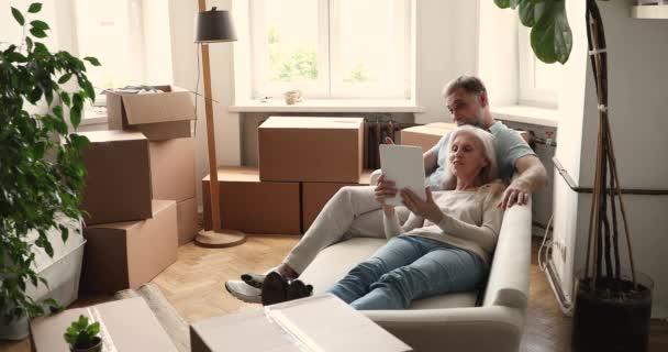 Senior couple use tablet buy furniture online for new house — Stock Video