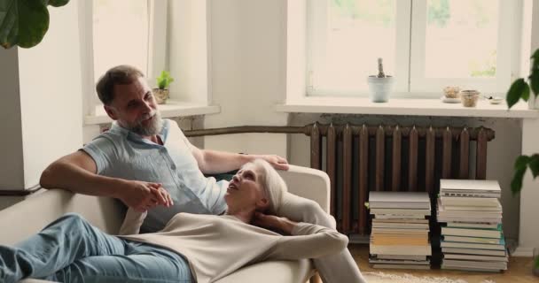 Starší pár v lásce mluví relaxaci na pohovce doma — Stock video