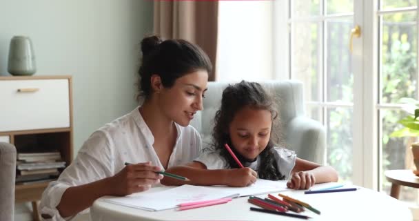 Indian mother cute little daughter drawing in sketchbook with pencils — ストック動画