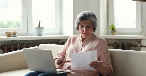 Ältere Frau checkt Versorgertarife, hat Probleme mit E-Bank-App — Stockvideo