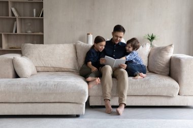 Sevgili babacığın küçük oğluna ve kızına kitap okuyor.