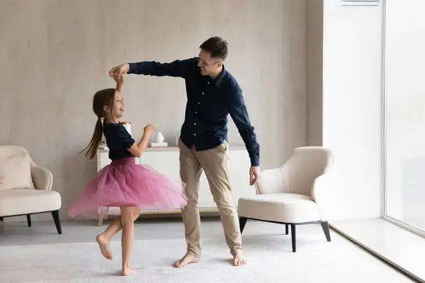 Счастливый папа учит прекрасную дочь танцевать в балетной юбке — стоковое фото
