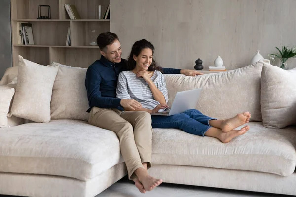 Happy sweet young couple watching movie on laptop — Stock Photo, Image