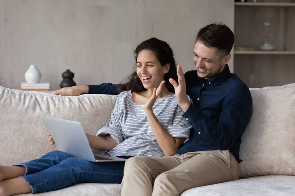 Glückliche Millennial-Eheleute nutzen Laptop für Videoanrufe von zu Hause aus — Stockfoto