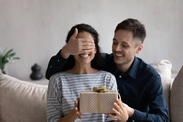 Lykkelig mann som gir en overraskende gave til den opphissede kona – stockfoto