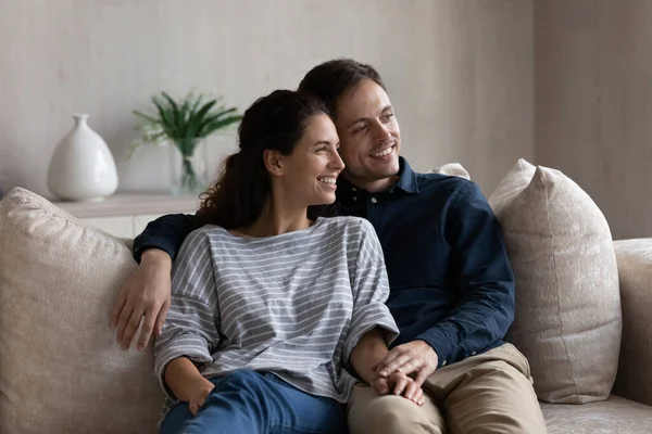 Счастливая супружеская пара отдыхает дома на диване — стоковое фото