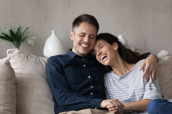 Χαρούμενο ζευγάρι χιλιετιών χαλαρώνει και γελάει στον καναπέ — Φωτογραφία Αρχείου