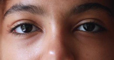 Yakından, gülümseyen Afrikalı genç kız kameraya bakıyor.