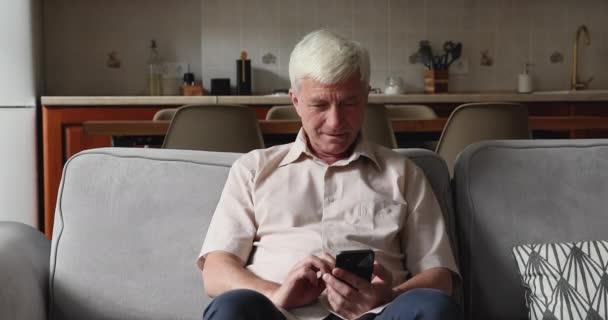 Man houdt mobiele telefoon, voelt zich blij met goed nieuws in sms — Stockvideo