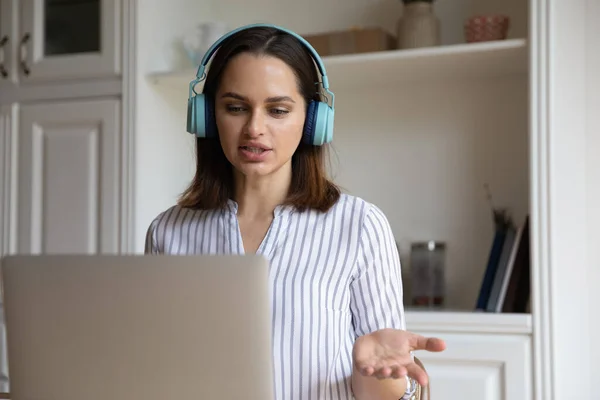 Focused smart young businesswoman in headphones holding video call meeting. — Stock Photo, Image
