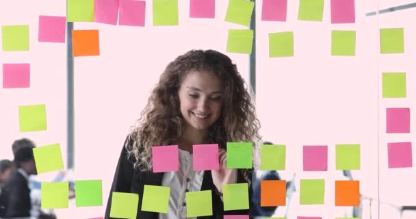 Ung kvinna arbetar med kanban planeringstavla i modernt kontor — Stockvideo