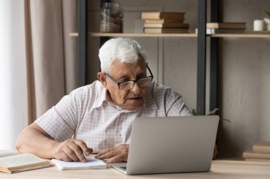 Odaklanmış yaşlı 80 'lerin öğrencisi bilgi topluyor.