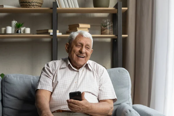 Happy starší muž držení, pomocí on-line aplikace elektronického obchodu na telefonu — Stock fotografie