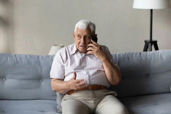 Starostlivý starší muž mluví z mobilu k doktorovi — Stock fotografie
