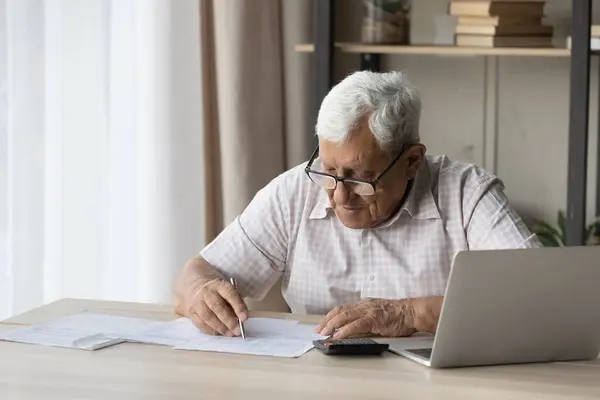 高齢者シニア80代男性で眼鏡で行う事務処理で自宅 — ストック写真