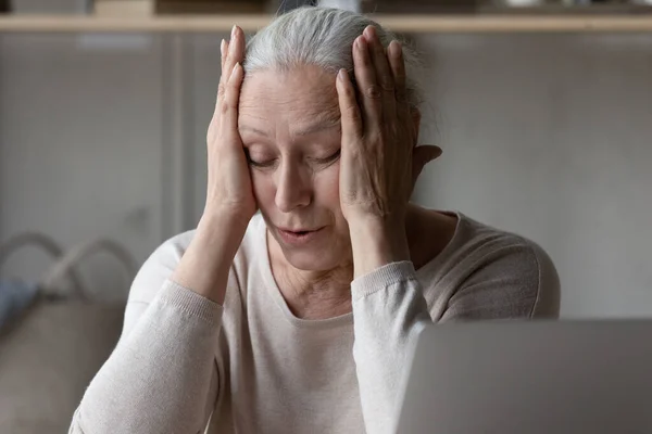 疲れました欲求不満な成熟した退職した女性タッチ頭で閉じた目 — ストック写真