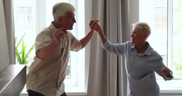 Levendig gelukkige oudere vijftiger jaren echtgenoten dansen thuis — Stockvideo