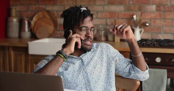 Afro americano homem remoto trabalhador usar laptop falar por telefone — Vídeo de Stock