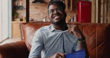 Yorgun genç siyah erkek kendini çok sıcak hissediyor kağıt yelpaze kullanıyor.