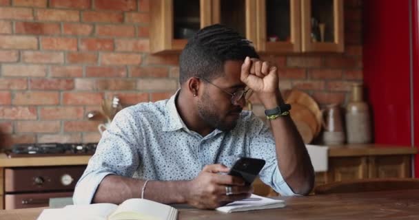Обеспокоенный молодой черный парень имеет дело с программным обеспечением проблемы на ячейке — стоковое видео