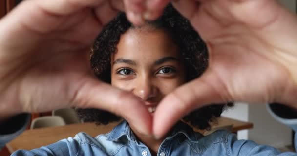Afričanky dospívající dívka ukazující symbol srdce se spojené prsty — Stock video