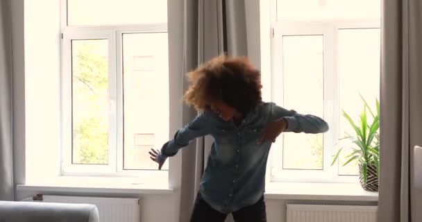 Zorgeloze Afrikaanse tiener meisje 17s dansen alleen thuis — Stockvideo