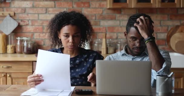 Preocupada pareja afroamericana dedicada a la contabilidad casera discutir las deudas — Vídeos de Stock