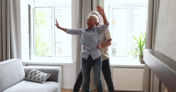 Sorridente coppia anziana innamorata che balla in salotto — Video Stock