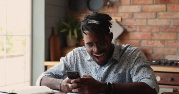 Radosny czarny facet krzyczy tak czyta niewiarygodne wiadomości na komórce — Wideo stockowe