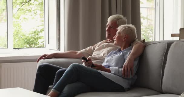 Äldre par byta kanal, välj favorit program avkopplande hemma — Stockvideo