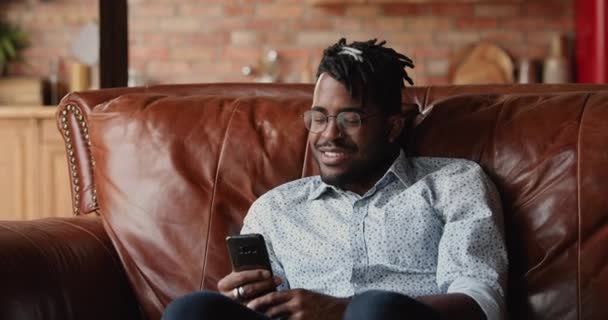 Preto masculino hipster resto dentro de casa usar telefone no lazer — Vídeo de Stock