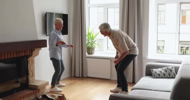 Vivaces cónyuges mayores bailando juntos en la acogedora sala de estar — Vídeo de stock