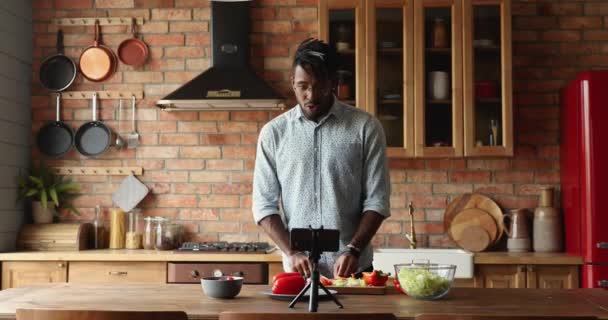 Młody czarny człowiek jedzenie blogger strzelać vlog w domu kuchnia — Wideo stockowe