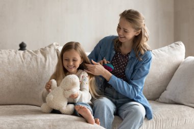 Neşeli genç anne, mutlu küçük kızıyla eğleniyor.