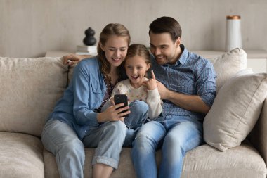 Mutlu aile ve küçük kız selfie çekiyorlar.