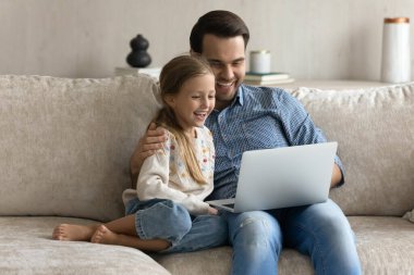 Mutlu baba ve gülen 7lerin kızı dizüstü bilgisayar kullanıyor.