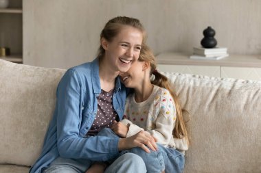 Mutlu bir genç anne ve neşeli bir çocuk sarılıyor.