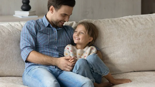 Felice amorevole papà coccole, abbracciando piccola figlia sul divano — Foto Stock